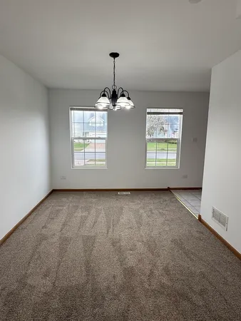 an empty room with windows and chandelier