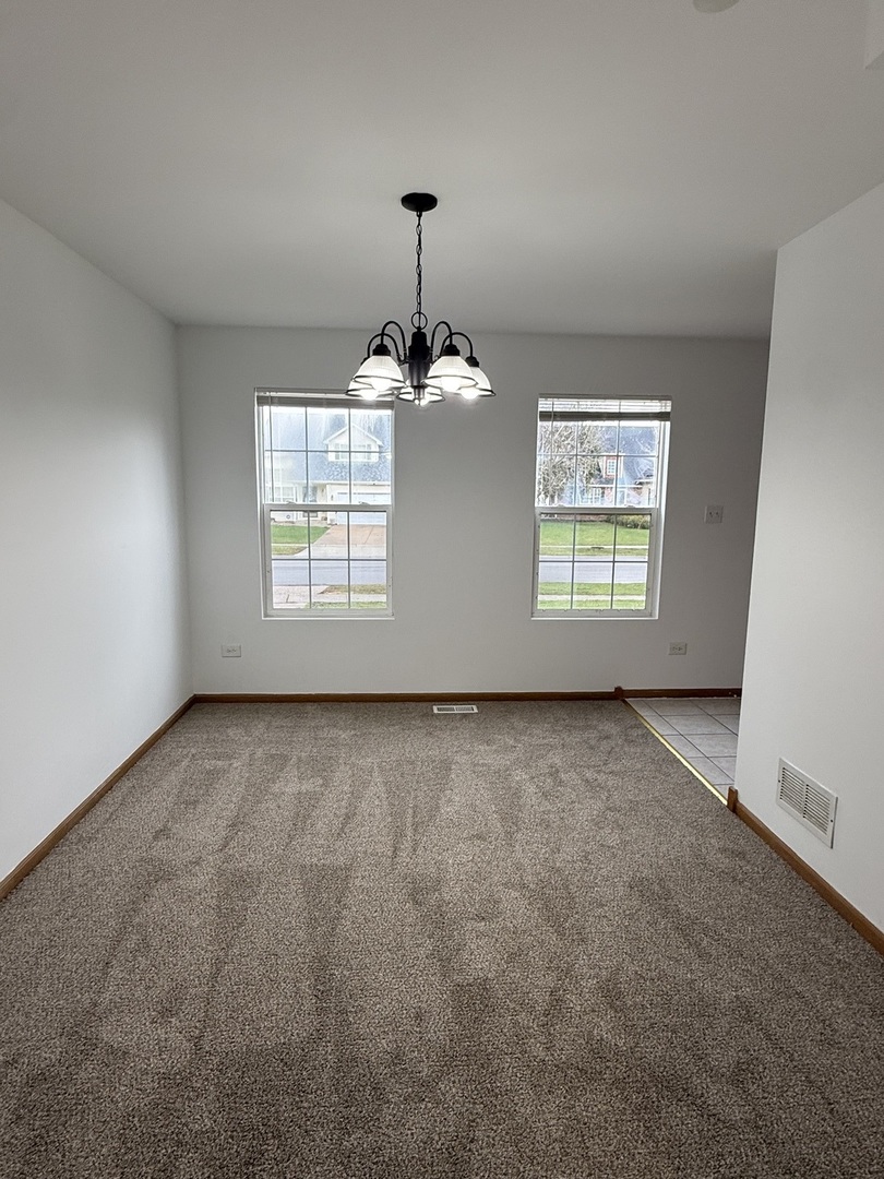 1004 Ann Street Joliet, IL 60435 - Photo 10 of 33 an empty room with windows and chandelier