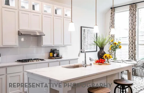 a kitchen with stainless steel appliances a sink a stove and white cabinets