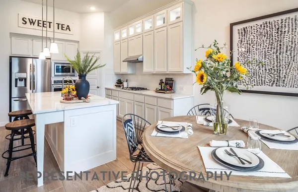 a kitchen with stainless steel appliances a sink a table and chair