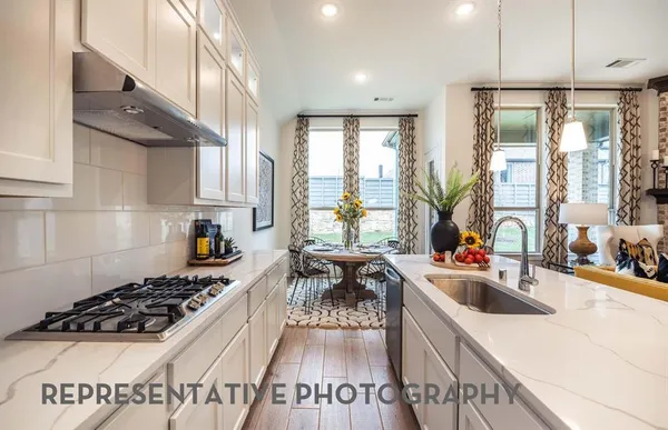a kitchen with stainless steel appliances a stove a sink a refrigerator and cabinets