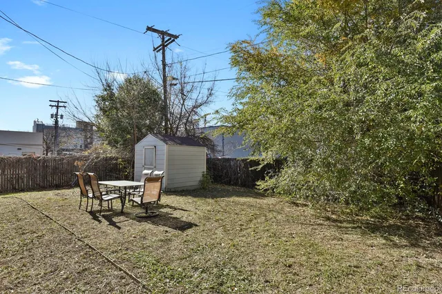 a roof deck with table and chairs and potted plants