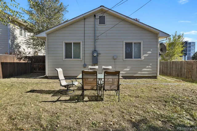 a backyard of a house with table and chairs