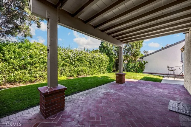 a view of a patio with table and chairs and potted plants with wooden fence