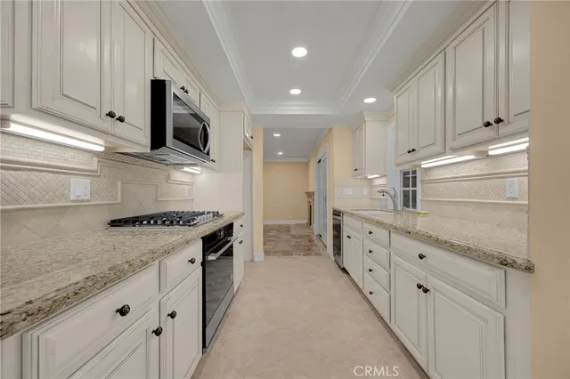a large kitchen with granite countertop a sink and a stove