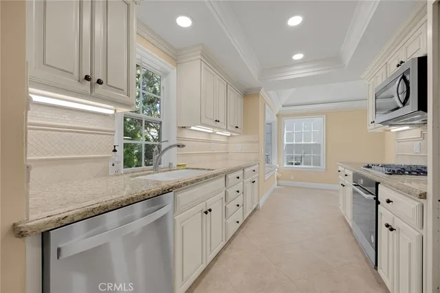 a kitchen with granite countertop white cabinets and white appliances