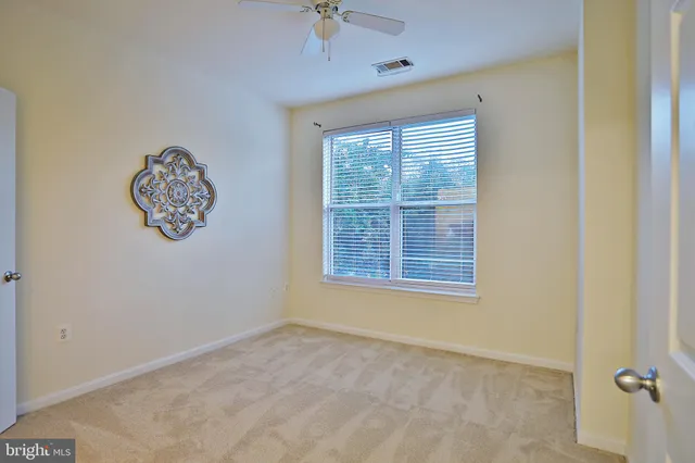 an empty room with a window and a fan