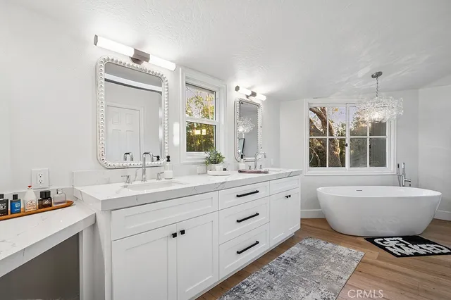 a bathroom with a double vanity sink mirror and bathtub