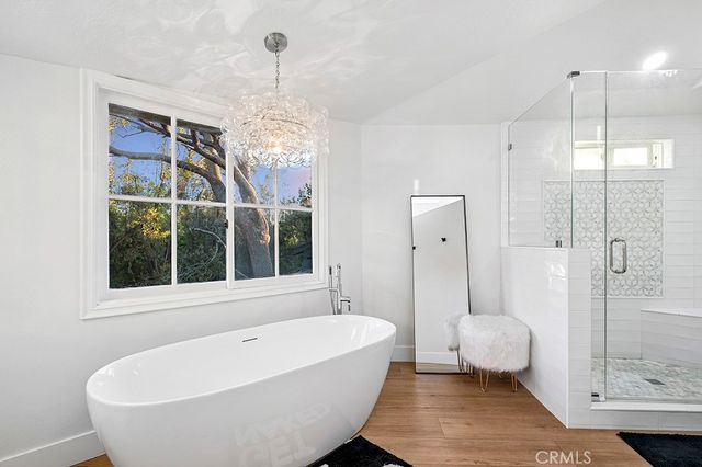 a bathroom with a tub a window and a shower