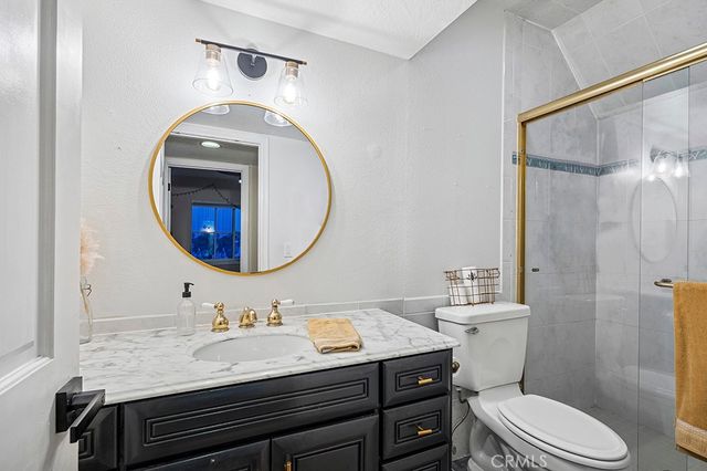 a bathroom with a granite countertop toilet sink and mirror