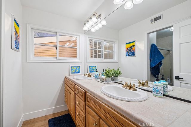 a bathroom with a granite countertop sink and a mirror