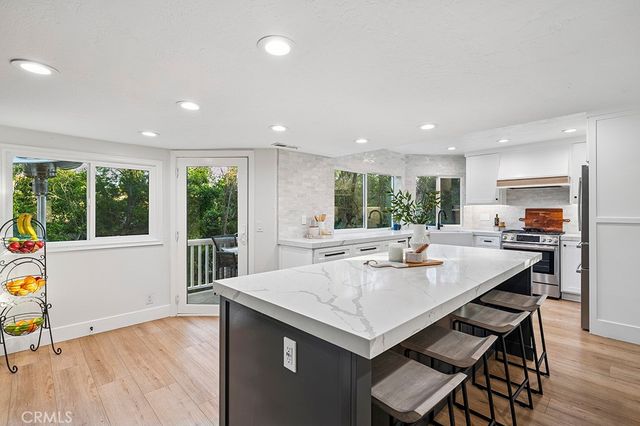 a kitchen with a table chairs and wooden floor