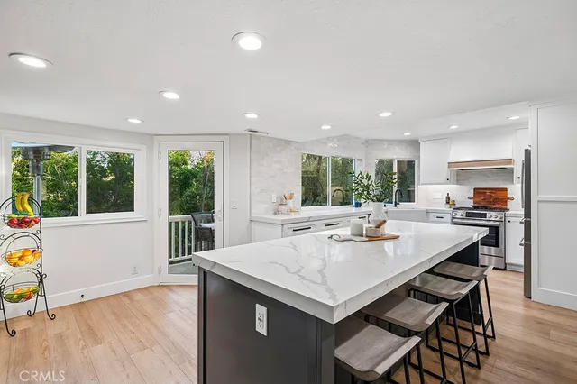 a kitchen with a table chairs and wooden floor