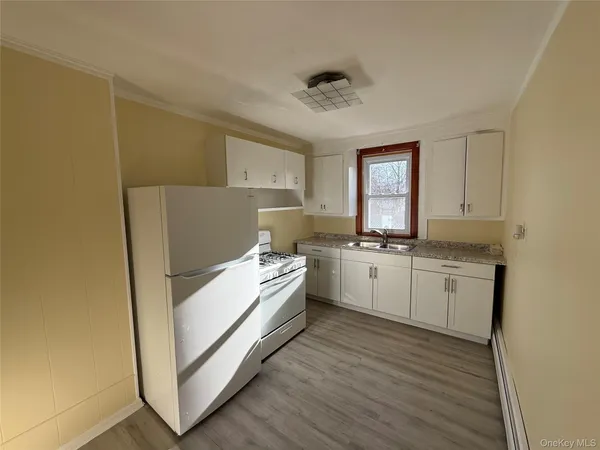 a kitchen with white cabinets and white appliances