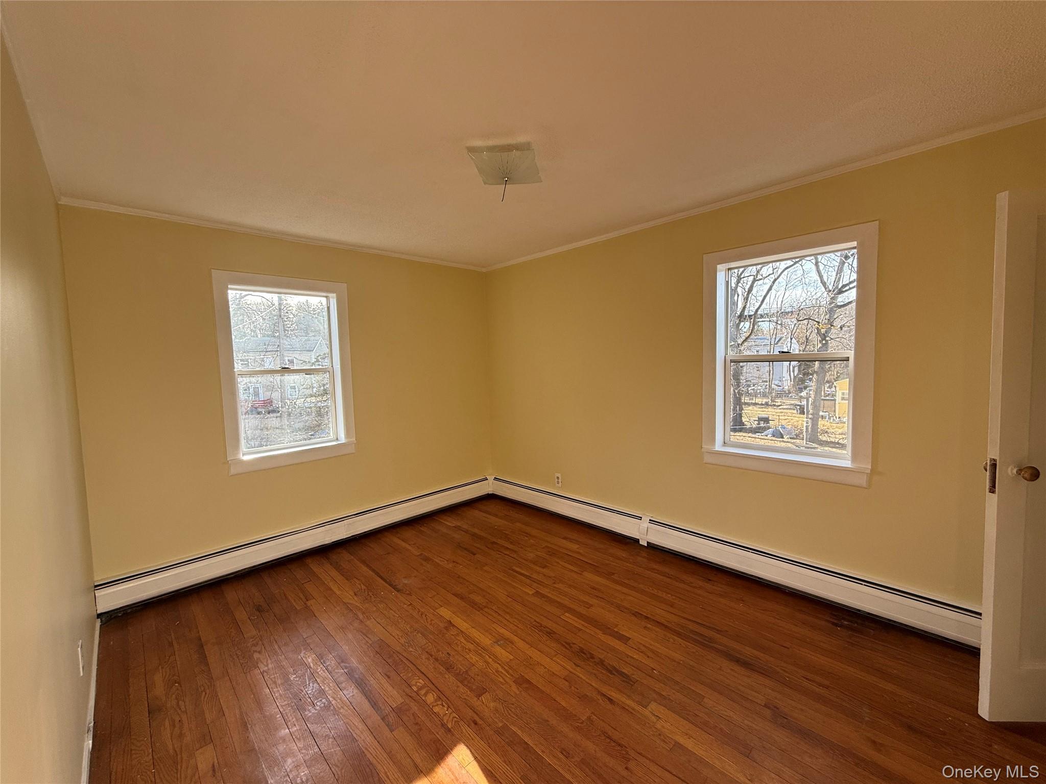 62 Talmadge Street, Unit 2 Poughkeepsie, NY 12601 - Photo 3 of 5 a view of an empty room with wooden floor and a window
