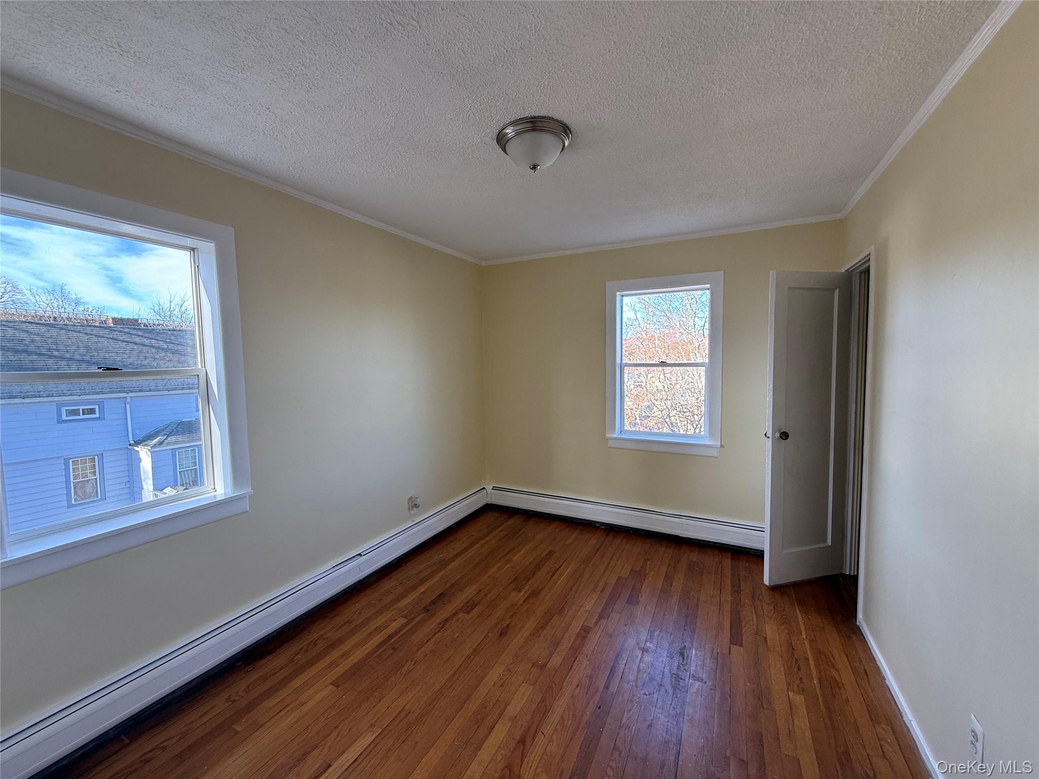 62 Talmadge Street, Unit 2 Poughkeepsie, NY 12601 - Photo 4 of 5 a view of an empty room with wooden floor and a window