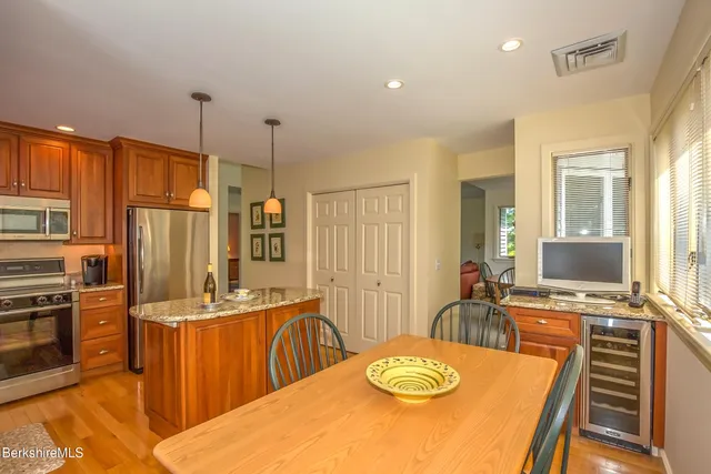 a kitchen with stainless steel appliances wooden floor dining table and chairs