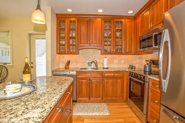a kitchen with stainless steel appliances granite countertop a stove top oven a sink and dishwasher
