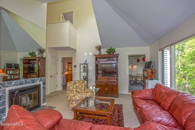 a living room with furniture a fireplace and a large window