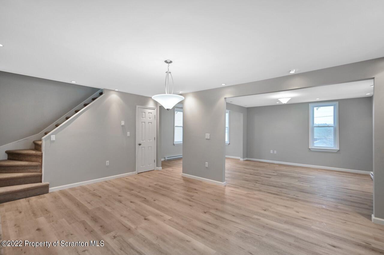 115 West High Street Taylor, PA 18517 - Photo 11 of 38 a view of an empty room with wooden floor kitchen view and a window