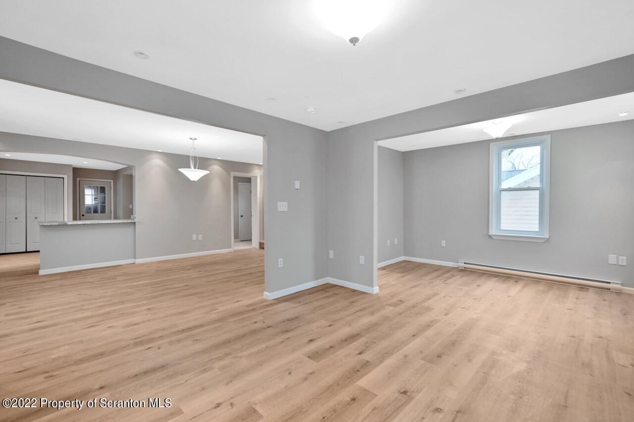 115 West High Street Taylor, PA 18517 - Photo 12 of 38 a view of an empty room with wooden floor and a window