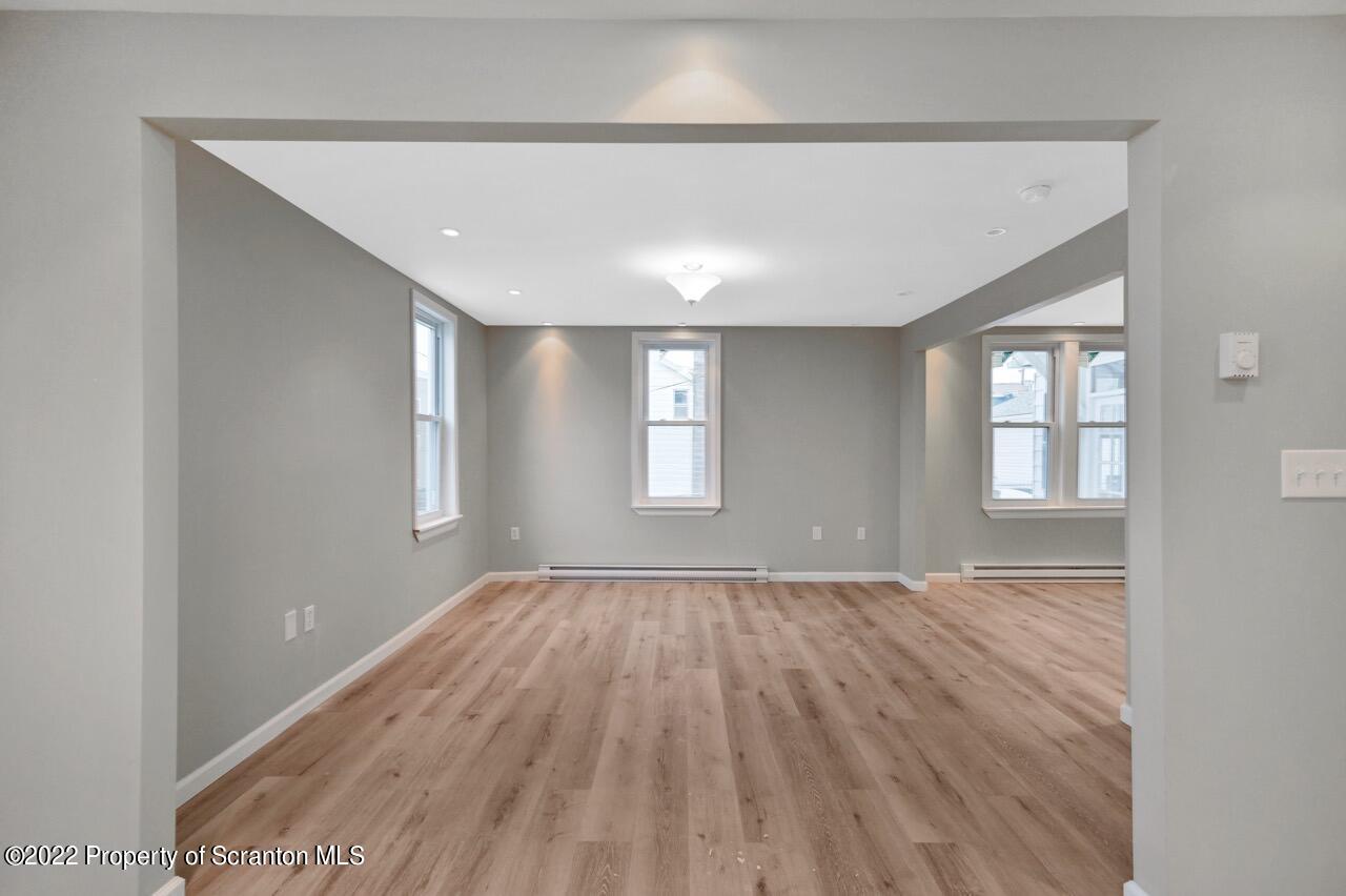 115 West High Street Taylor, PA 18517 - Photo 14 of 38 a view of an empty room with wooden floor and a window