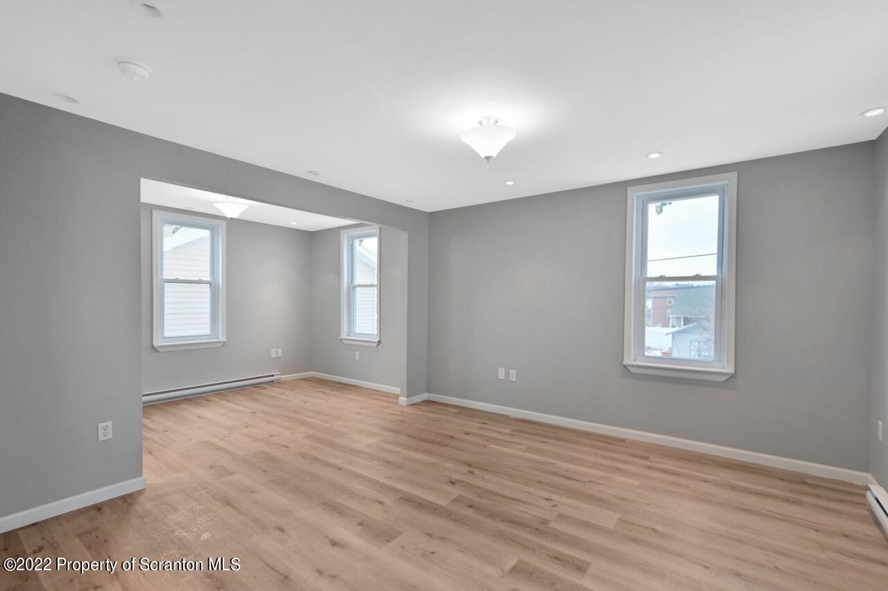 115 West High Street Taylor, PA 18517 - Photo 15 of 38 a view of an empty room with wooden floor and a window