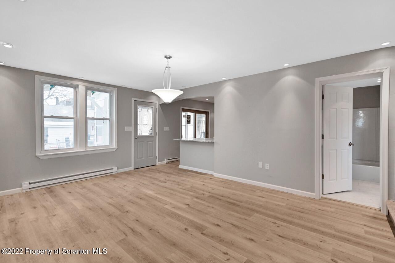 115 West High Street Taylor, PA 18517 - Photo 16 of 38 a view of an empty room with window and wooden floor