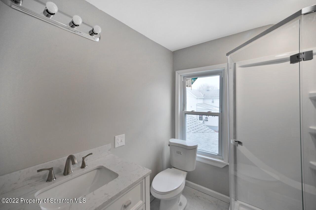 115 West High Street Taylor, PA 18517 - Photo 27 of 38 a bathroom with a granite countertop sink toilet a mirror and shower