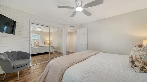 a bedroom with a large bed and a ceiling fan