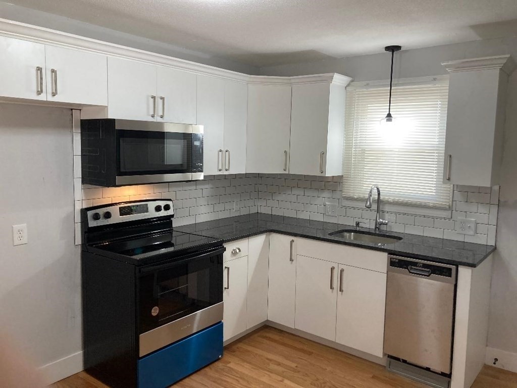76 Darling Street Springfield, MA 01151 - Photo 5 of 14 a kitchen with appliances a sink and cabinets
