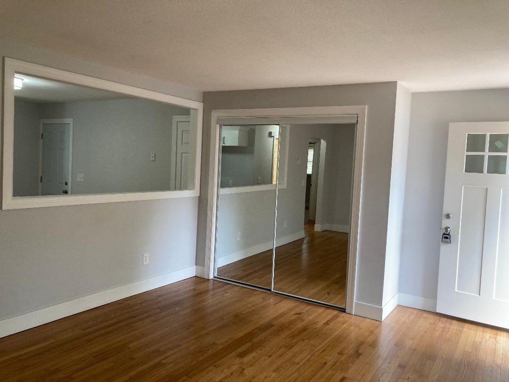 76 Darling Street Springfield, MA 01151 - Photo 9 of 14 an empty room with wooden floor and door