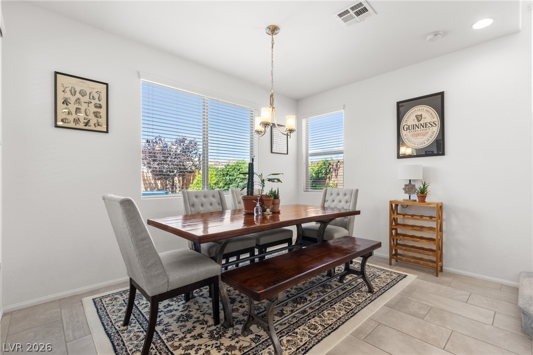 891 Earth Luster Road Las Vegas, NV 89178 - Photo 9 of 48 A refined dining space showcasing ample natural light and elegant tile flooring.