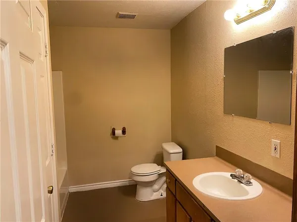 a bathroom with a sink a toilet and a mirror