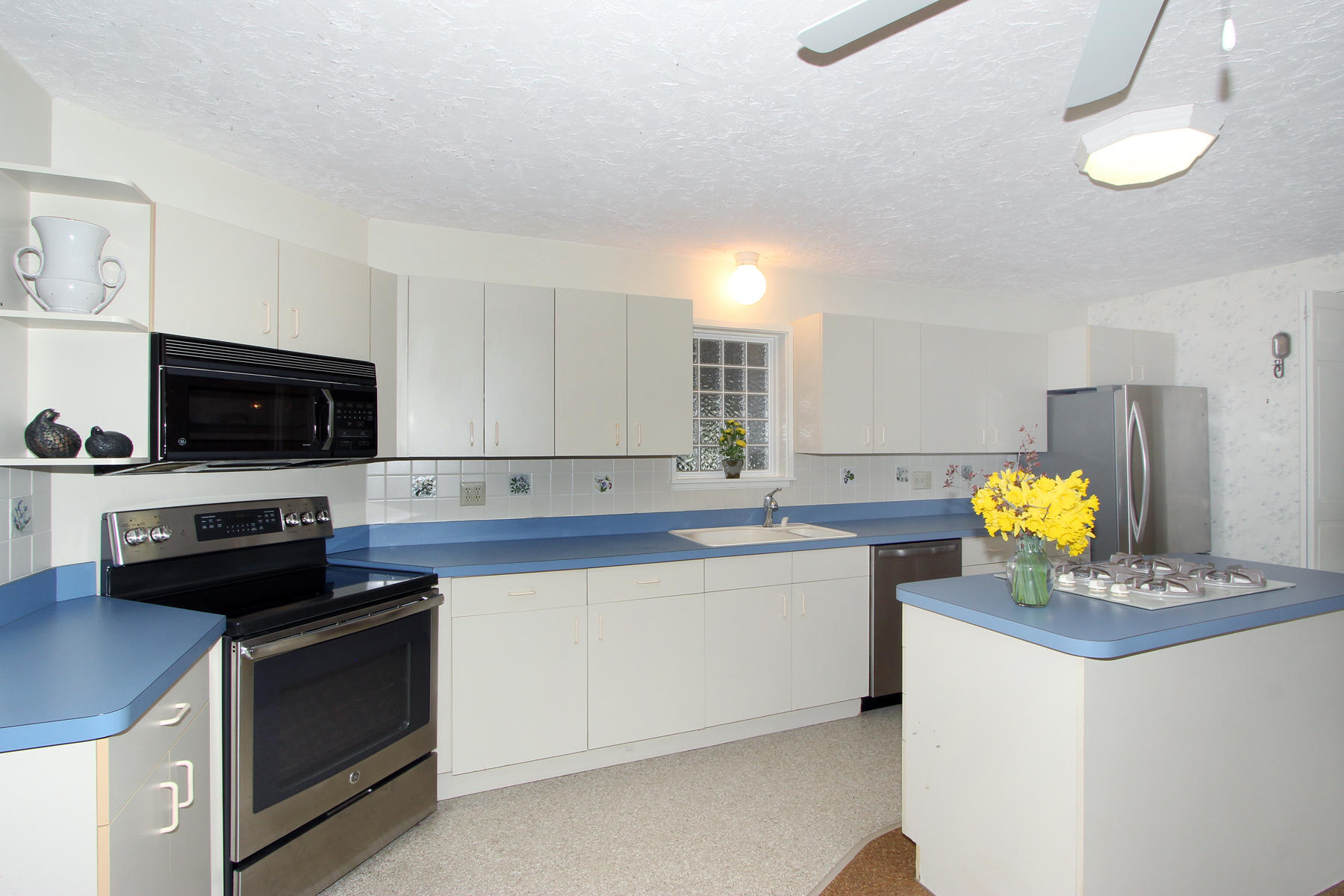 75 Lawton Road Eastham, MA 02642 - Photo 4 of 27 a kitchen with stainless steel appliances a stove a sink and a white cabinets