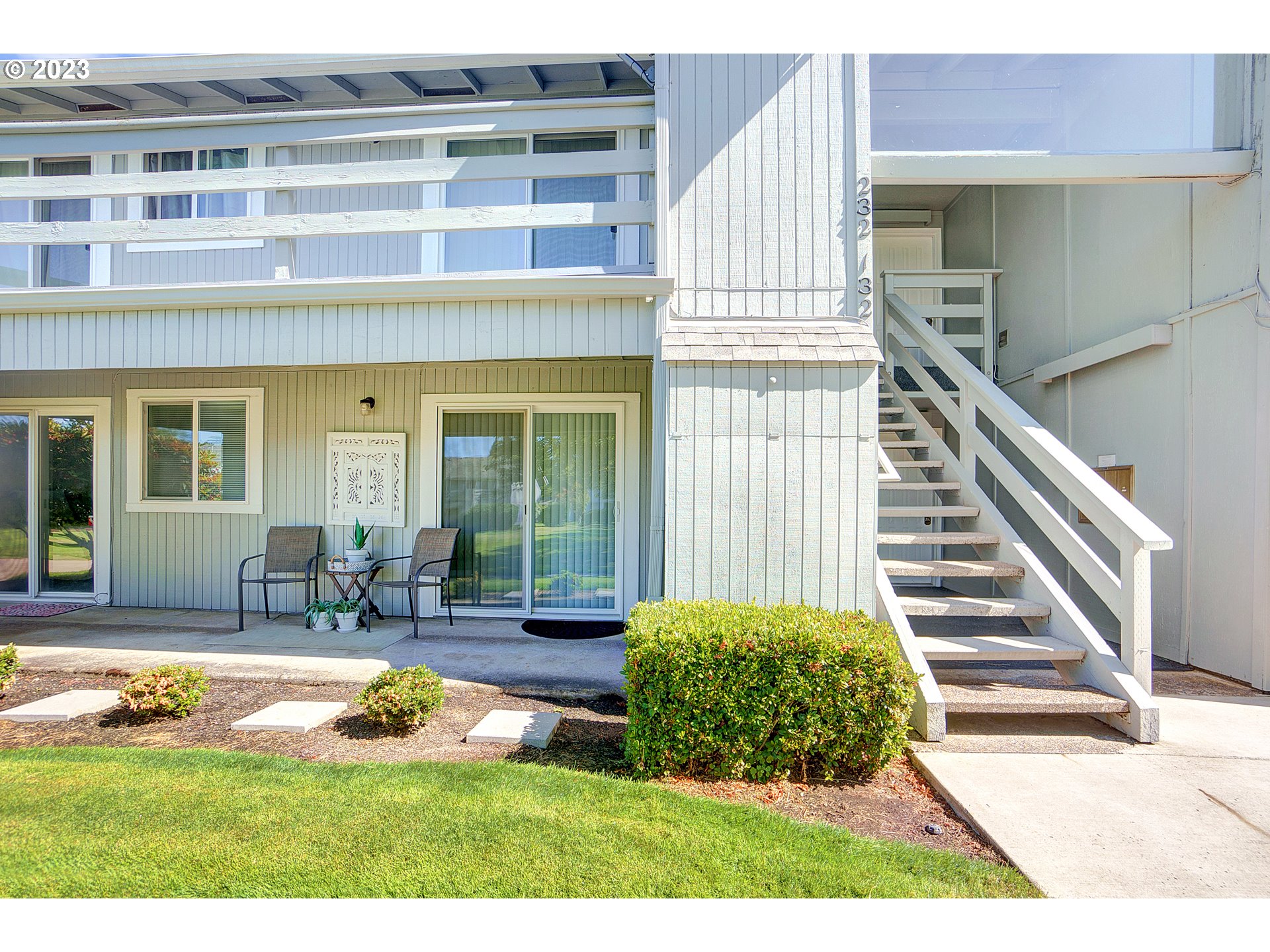 a view of a house with backyard and sitting area