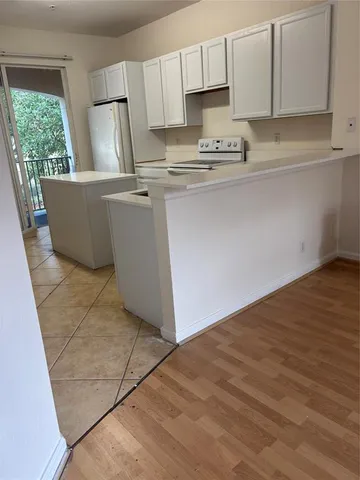 a kitchen with stainless steel appliances a sink a stove a refrigerator cabinets and a window