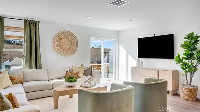 a living room with furniture a flat screen tv and a large window