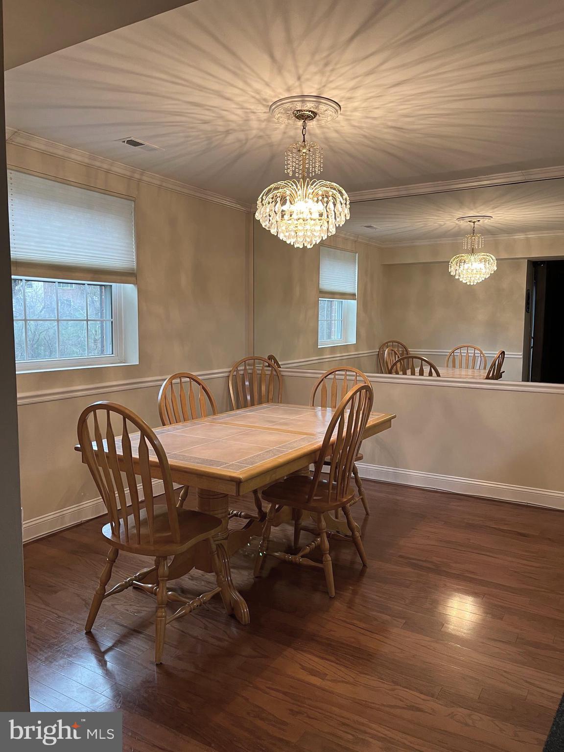 100 Castletown Road, Unit 101 Lutherville-Timonium, MD 21093 - Photo 3 of 18 a view of a dining room with furniture wooden floor and chandelier