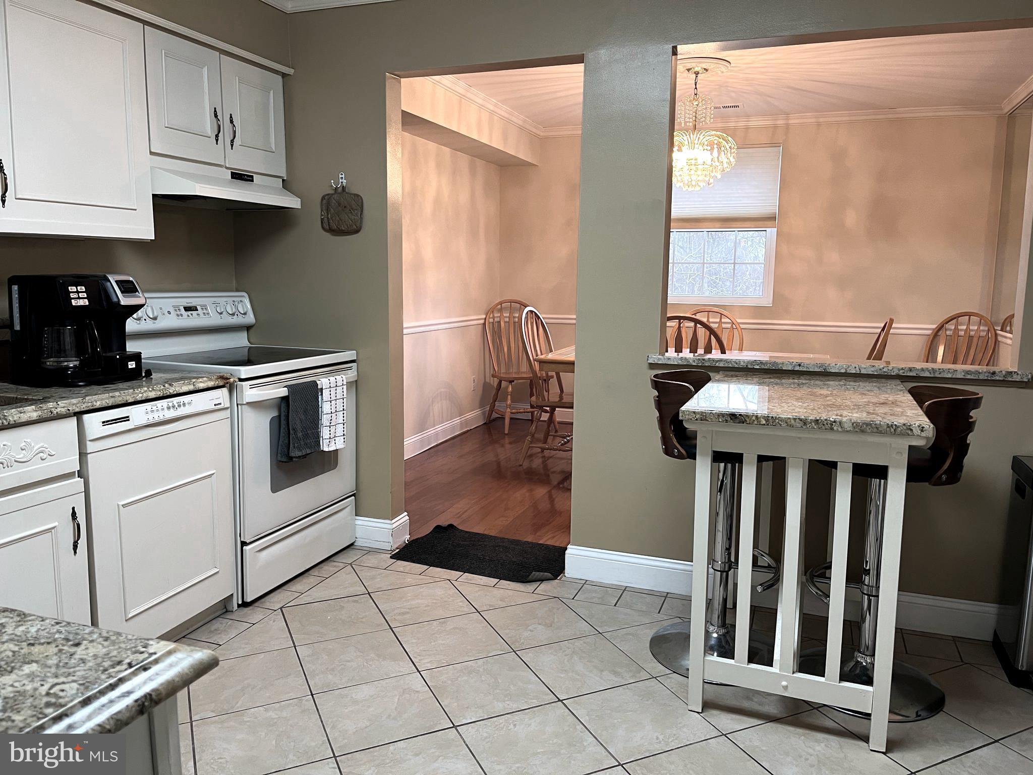 100 Castletown Road, Unit 101 Lutherville-Timonium, MD 21093 - Photo 6 of 18 a kitchen with granite countertop a sink stove and cabinets