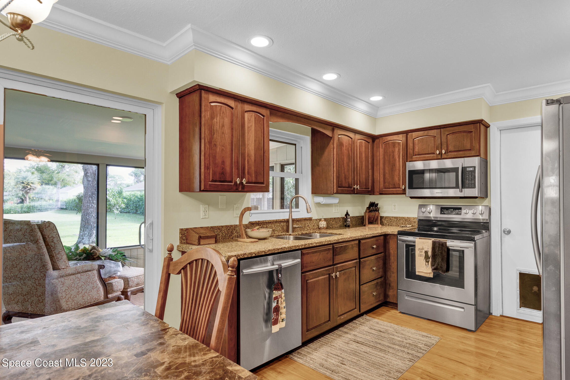 461 Easy Street Sebastian, FL 32958 - Photo 13 of 31 a kitchen with stainless steel appliances granite countertop a stove a sink dishwasher a refrigerator and a microwave oven with wooden cabinets