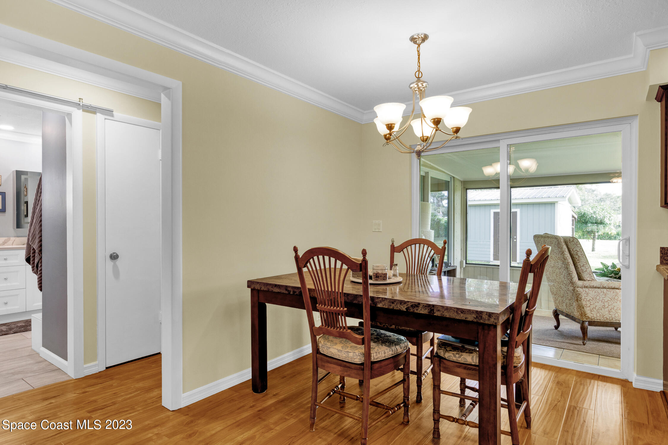 461 Easy Street Sebastian, FL 32958 - Photo 14 of 31 a dining room with furniture wooden floor a chandelier and a mirror
