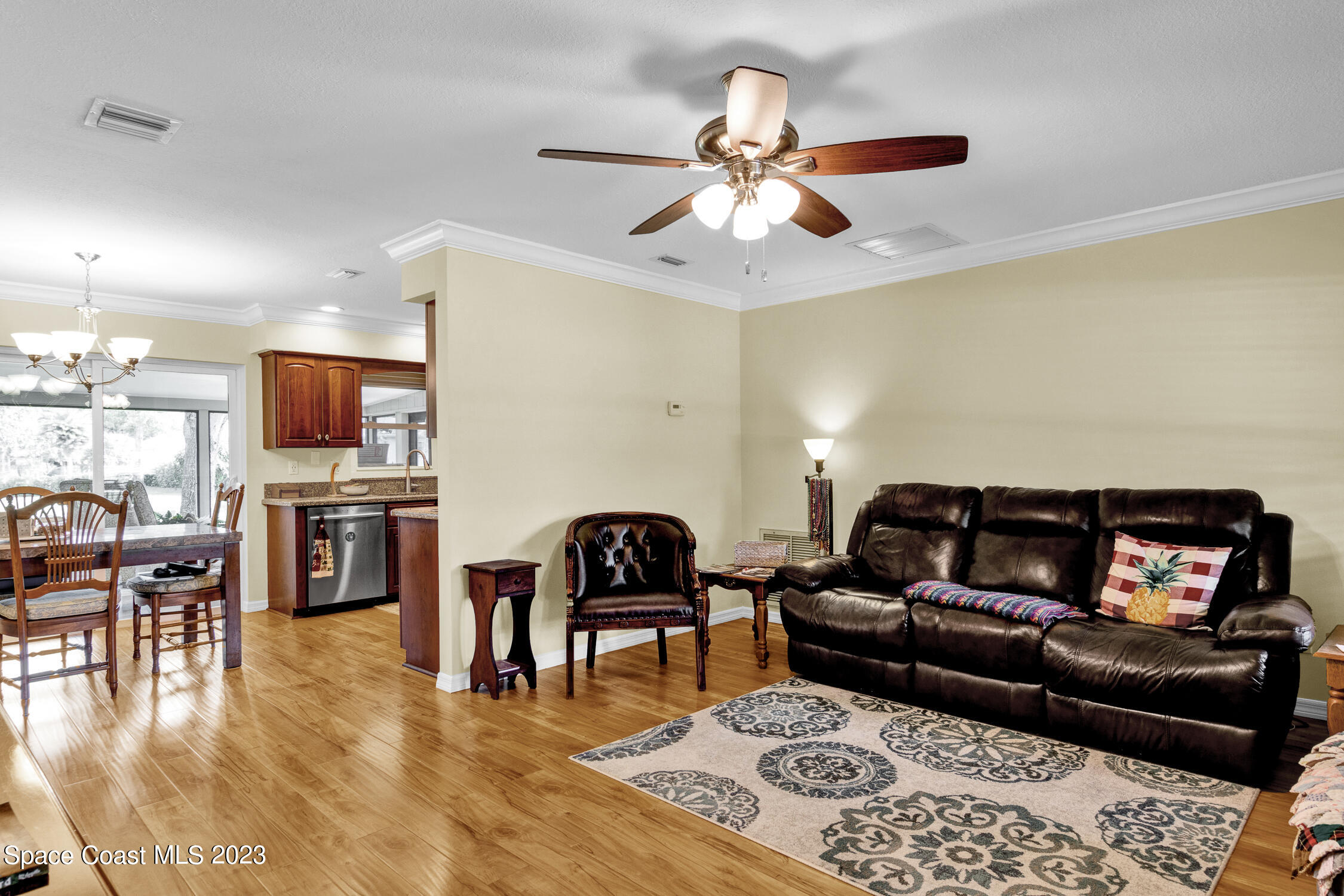 461 Easy Street Sebastian, FL 32958 - Photo 10 of 31 a living room with furniture and a flat screen tv with kitchen view