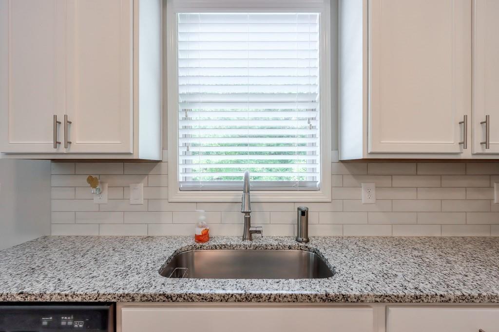 4688 Cantrell Road Flowery Branch, GA 30542 - Photo 16 of 39 a kitchen with granite countertop a sink and potted white wooden cabinets