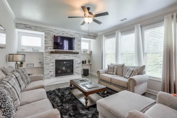 a living room with furniture a fireplace and a large window