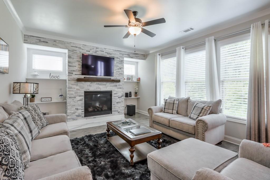 4688 Cantrell Road Flowery Branch, GA 30542 - Photo 17 of 39 a living room with furniture a fireplace and a large window