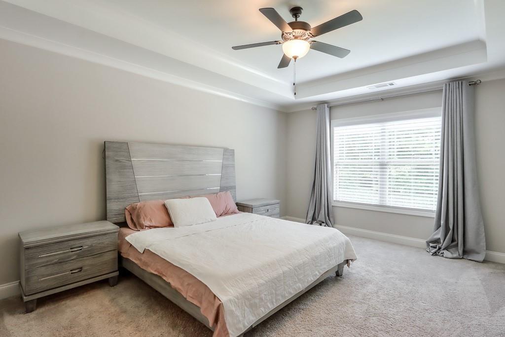 4688 Cantrell Road Flowery Branch, GA 30542 - Photo 21 of 39 a bedroom with a bed and a ceiling fan