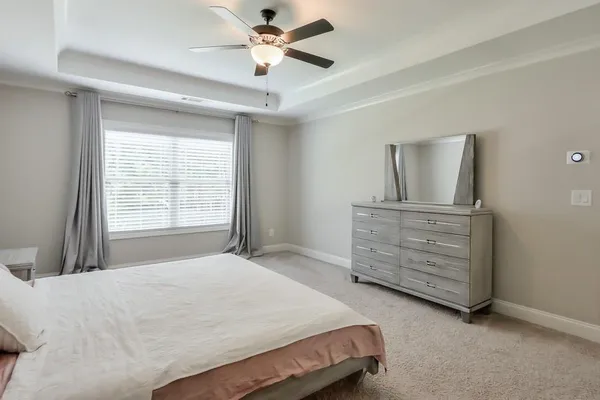 a bedroom with a bed a dresser and a window