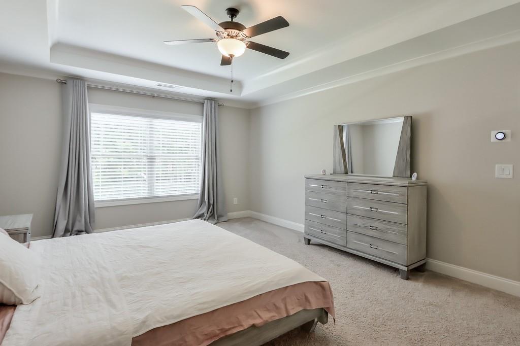 4688 Cantrell Road Flowery Branch, GA 30542 - Photo 22 of 39 a bedroom with a bed a dresser and a window