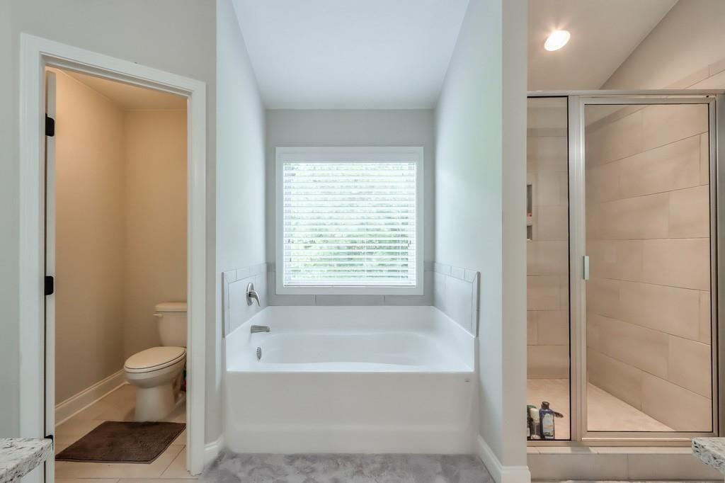 4688 Cantrell Road Flowery Branch, GA 30542 - Photo 24 of 39 a bathroom with a bathtub and a shower